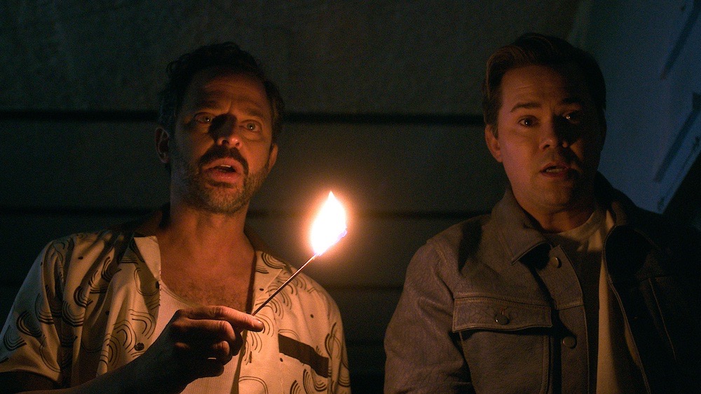 Nick Kroll and Andrew Rannells lit by a single match at night, I Don’t Understand You